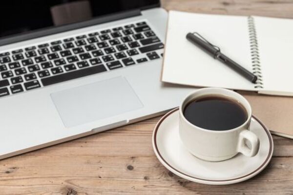 Notebook and coffee cup arranged neatly on a table